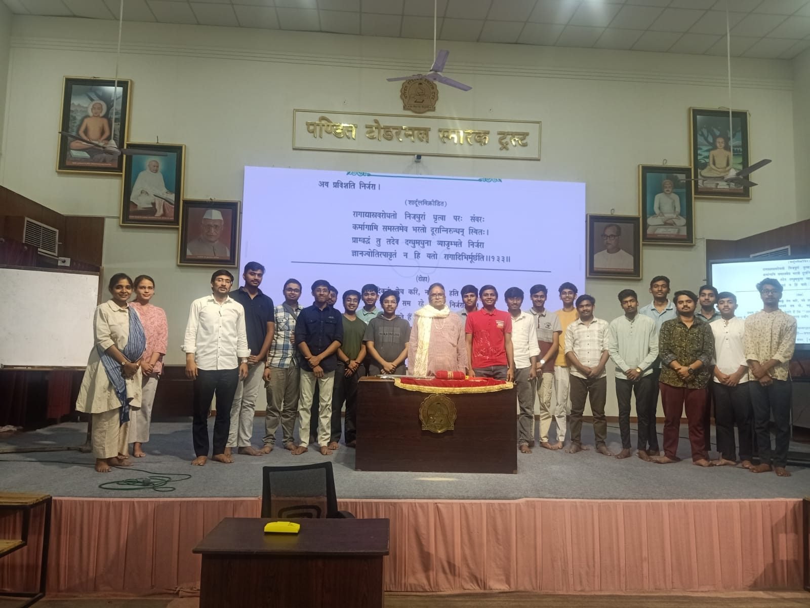 Participants standing in front of the dais at the close of a session