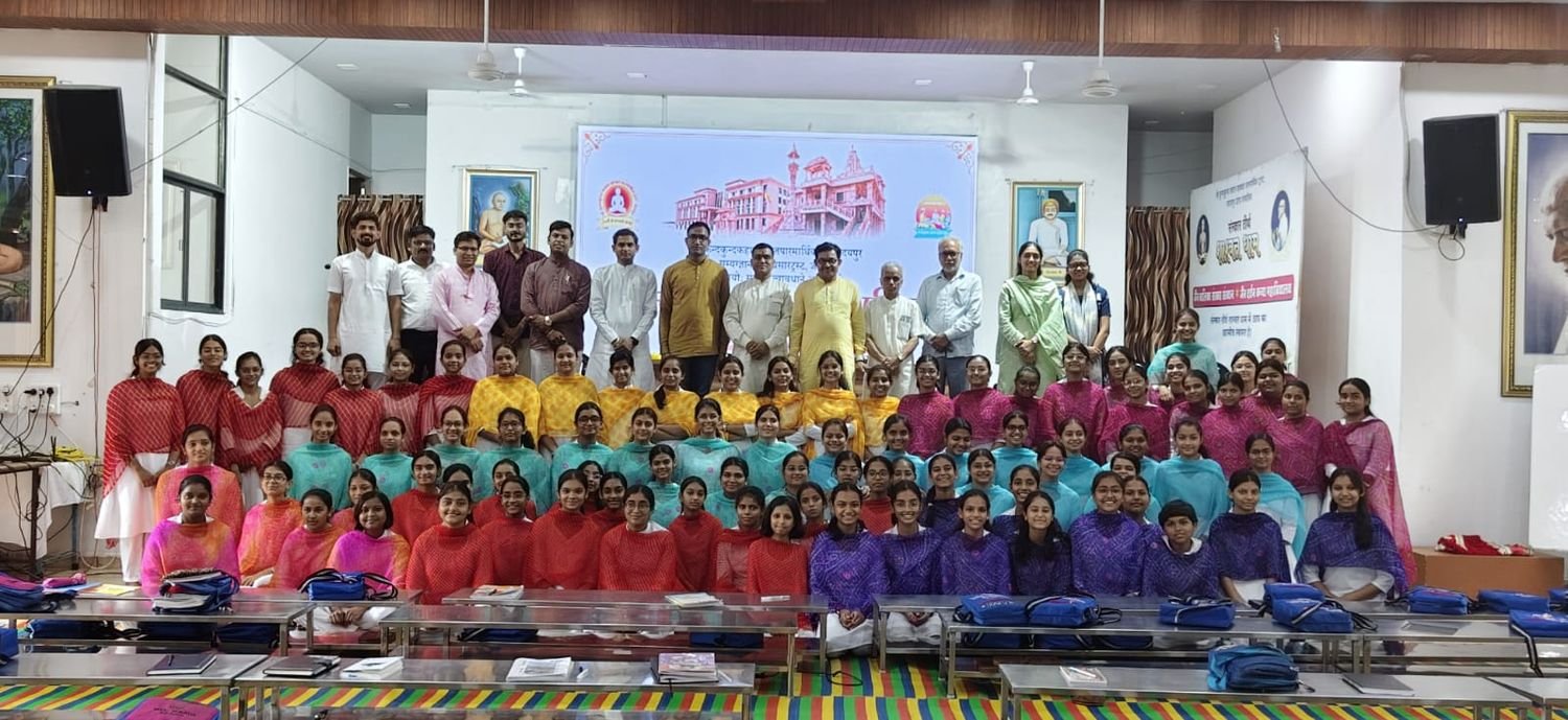 Rows of participants seated and standing in the hall, with the scholars and guests of the camp standing behind them