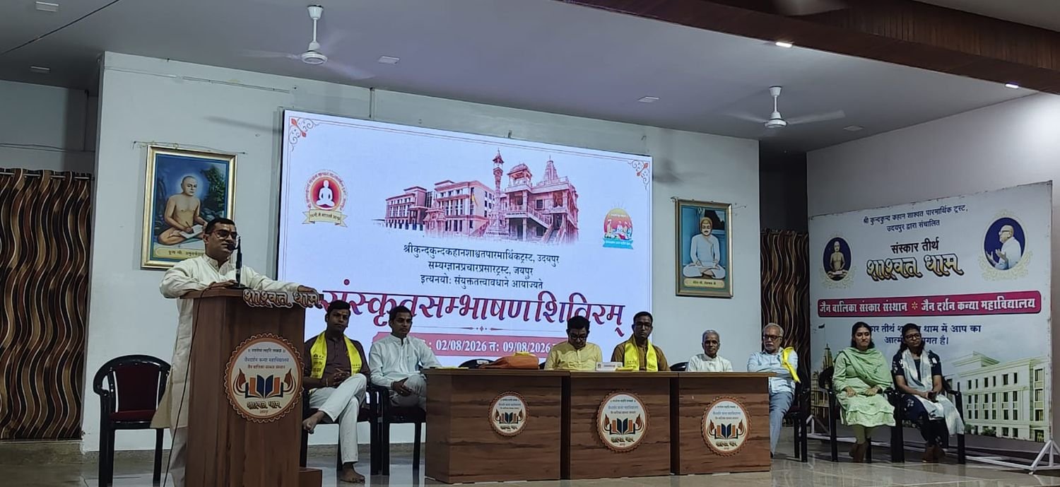 A speaker at the lectern addressing the inaugural session, the guests seated at the table on the dais and the projected announcement behind them