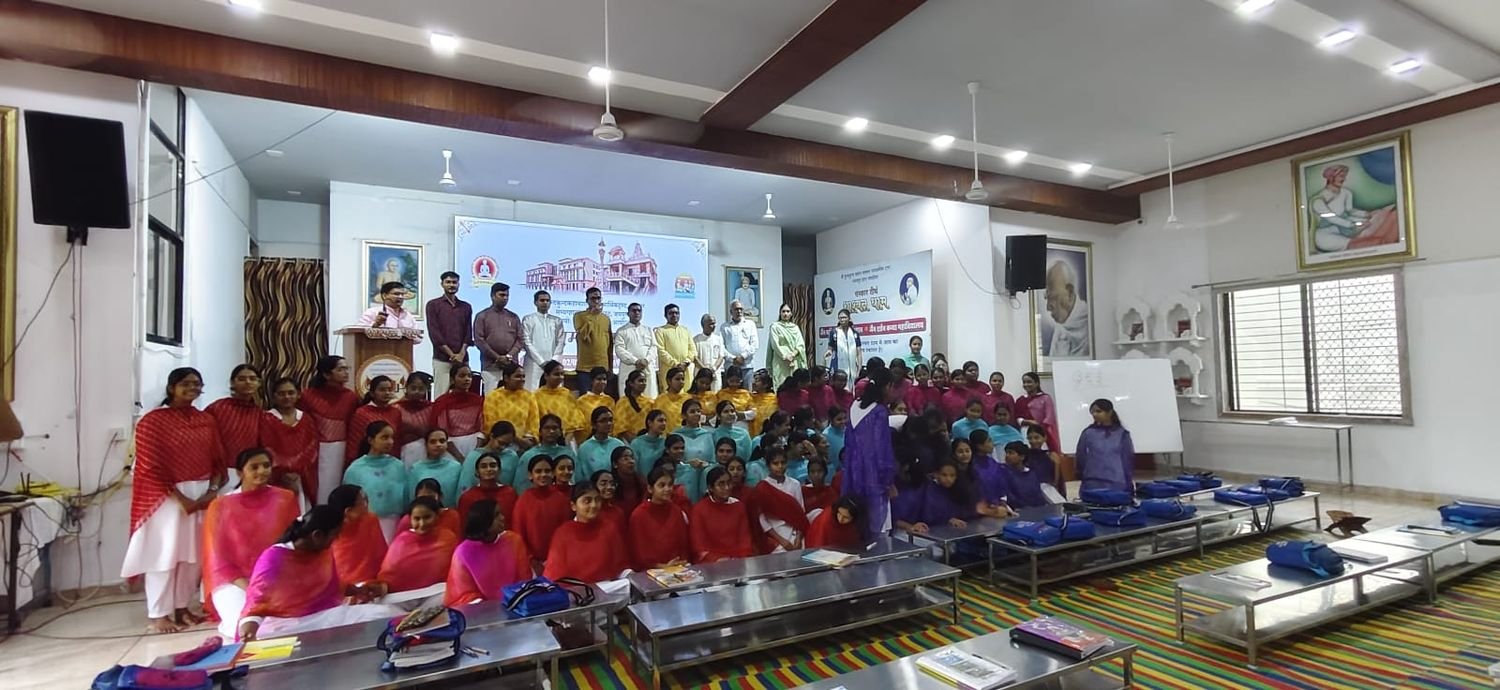 Participants standing together in the hall with the scholars of the camp, the projected announcement behind them